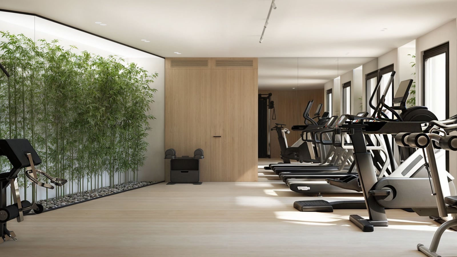 Modern fitness room featuring treadmills, ellipticals, and a decorative indoor bamboo wall.