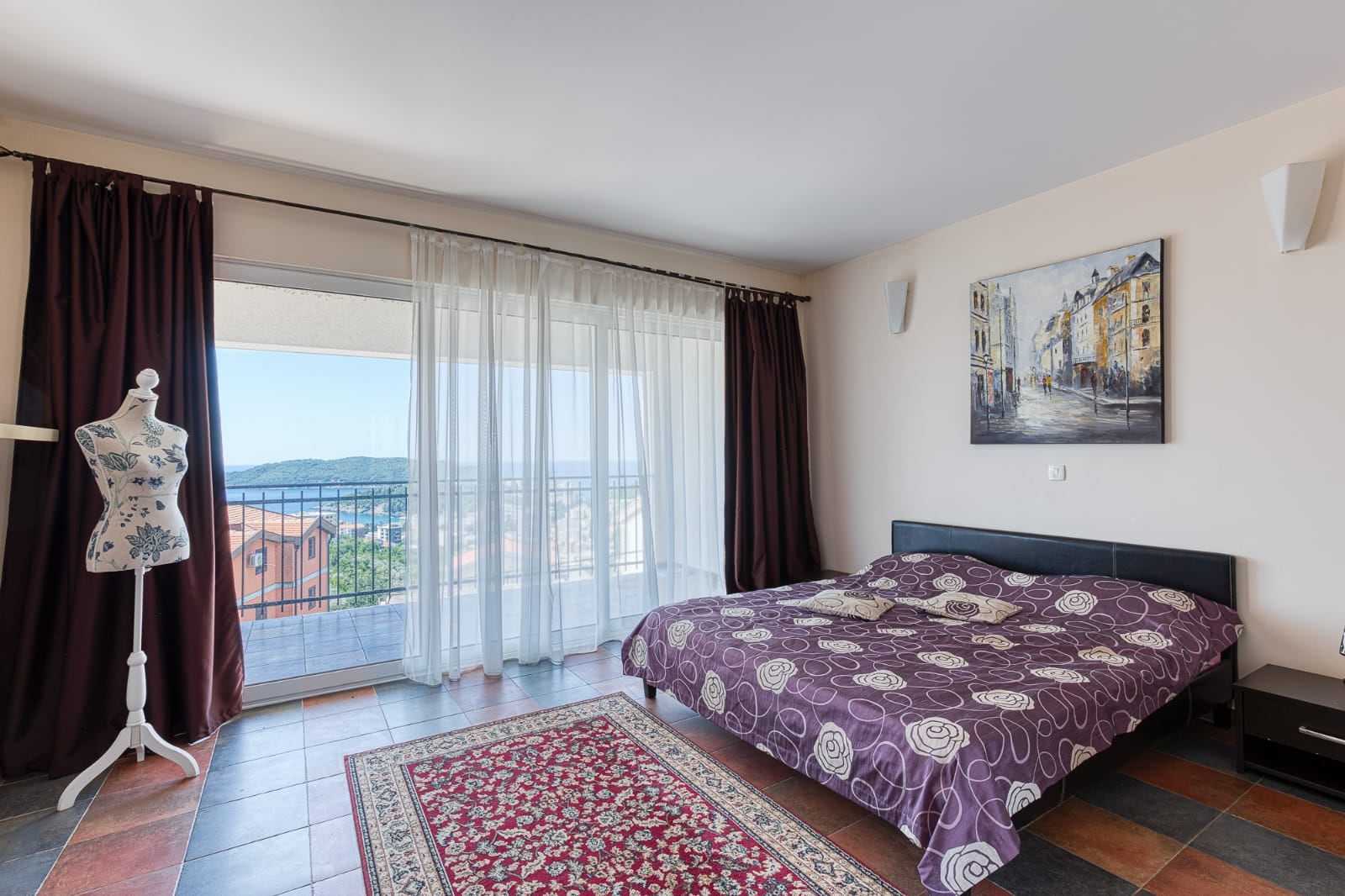 Bedroom in a villa in Bečići, Montenegro: double bed, panoramic sea view, and a balcony with a terrace.