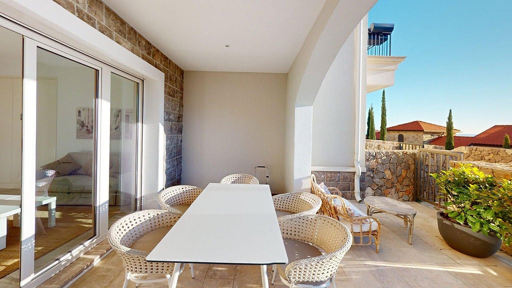 Spacious terrace with wicker furniture and sea view in a residential complex, Luštica, Montenegro.