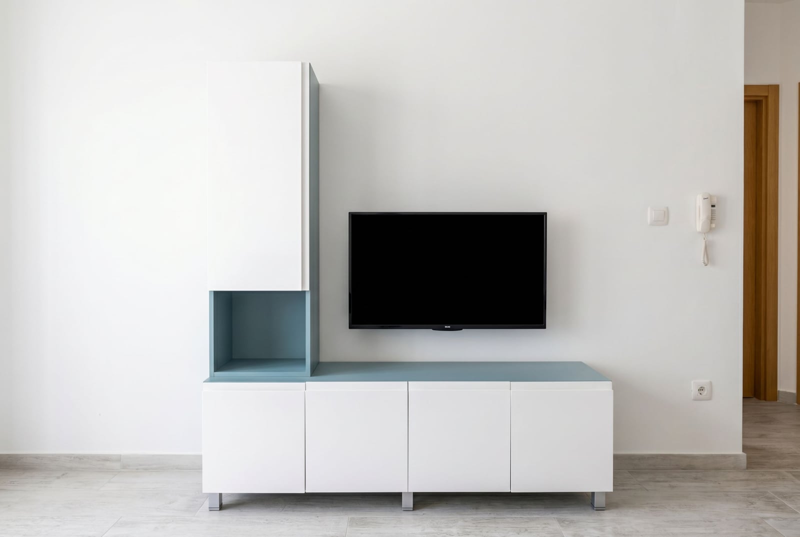 Modern living room with white furniture and TV in an apartment in Budva, Montenegro: stylish interior with wood-style finishes.