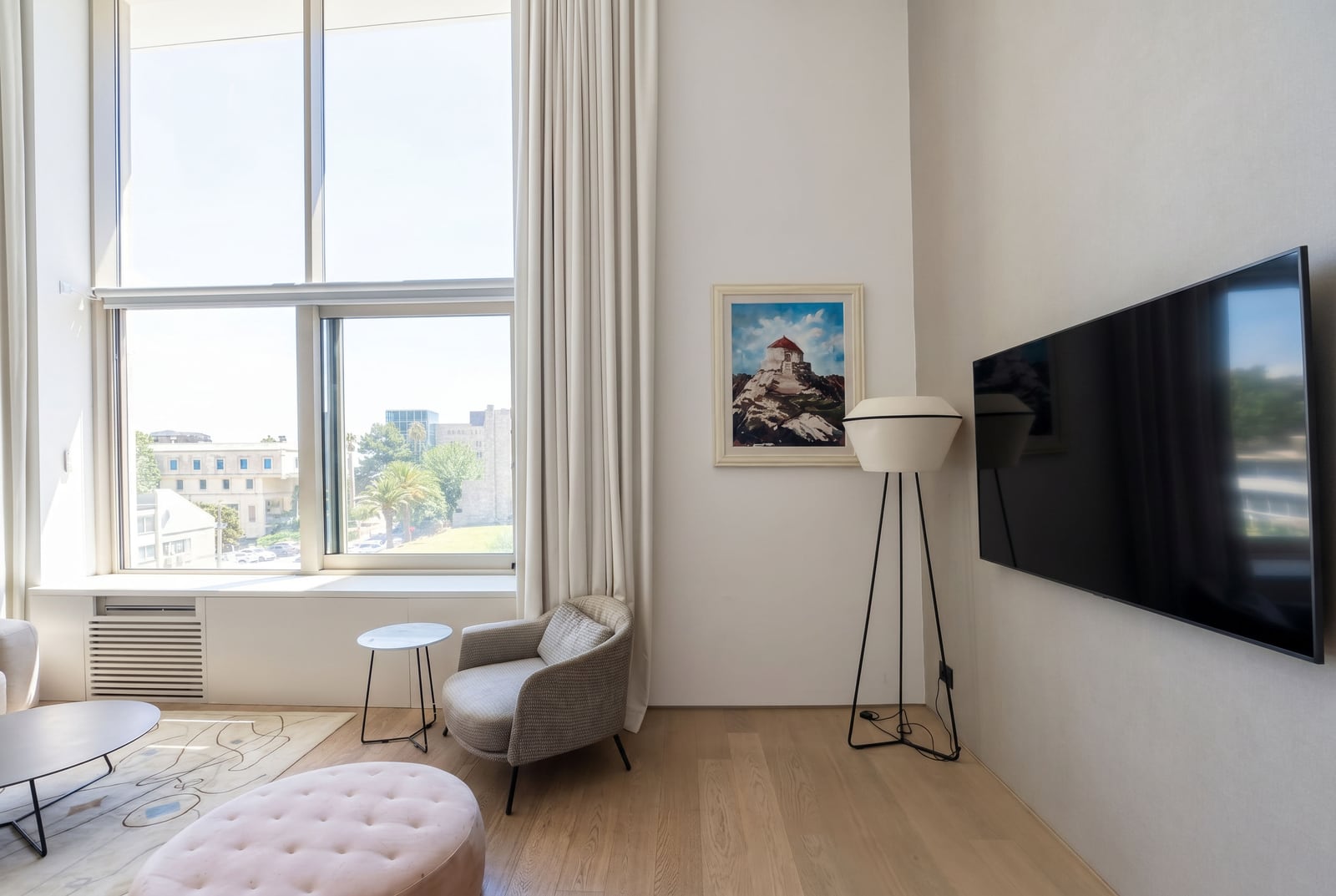 Living room in a modern apartment in Budva, Montenegro: panoramic windows, stylish furniture, TV, and bright interior finishes.