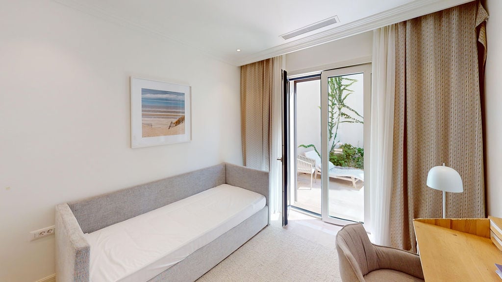 Bright bedroom with a sofa and terrace access in a residential complex, Luštica, Montenegro. Modern interior.
