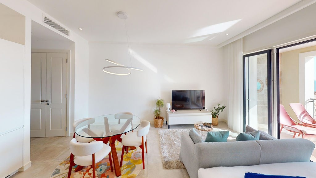 Modern living room with dining area in an apartment in Luštica, Montenegro: bright interior, terrace with a view.