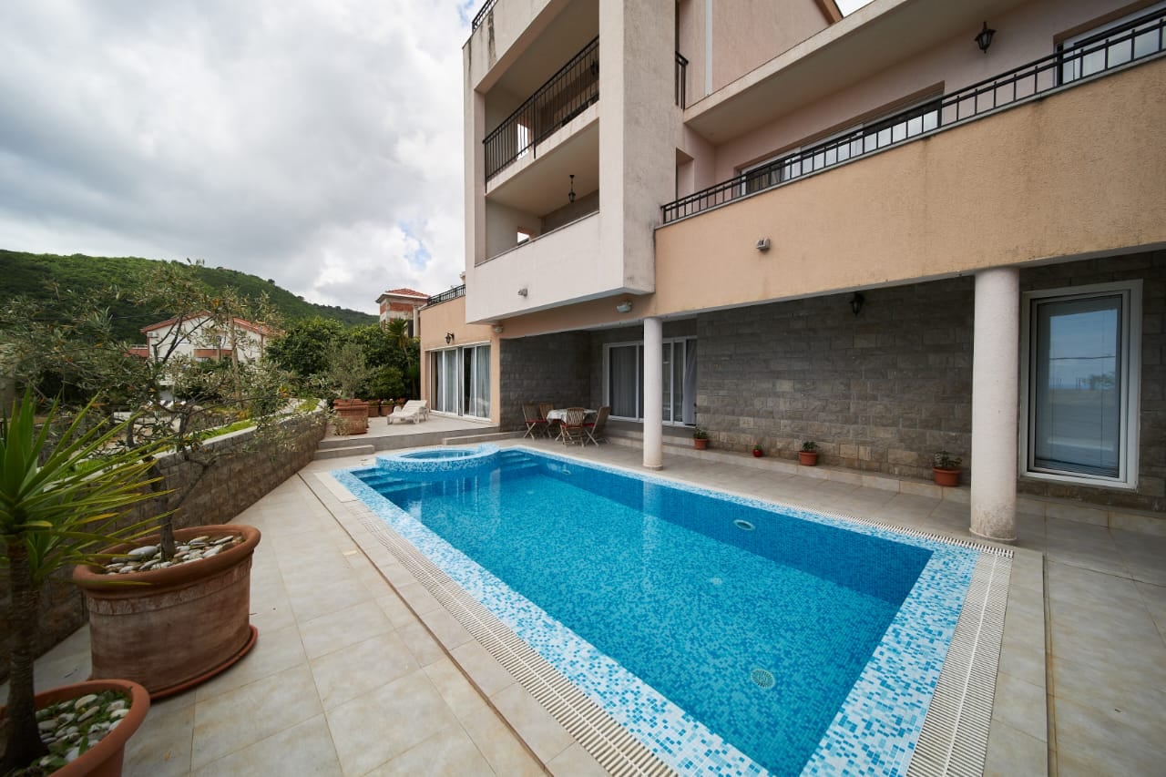 Private swimming pool with a lounge area at a villa in Bečići, Montenegro: modern stone finishes and a furnished terrace.
