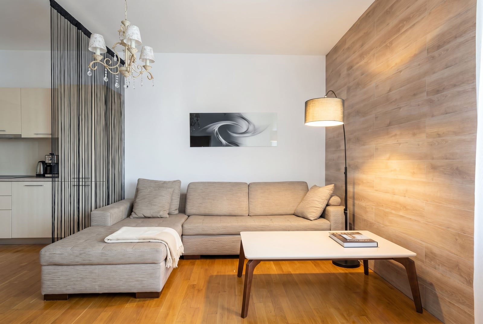 Modern living room in an apartment in Budva, Montenegro: corner sofa, coffee table, and stylish wood finish.