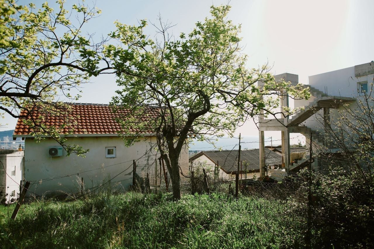 Land plot in Shushan, Montenegro: view of houses, garden, and the sea, a promising place to build a house.