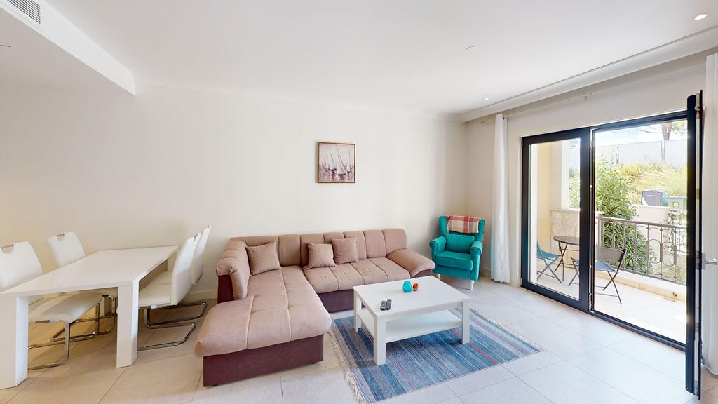 Bright living room with a corner sofa and terrace access in Lustica Bay apartments, Montenegro.