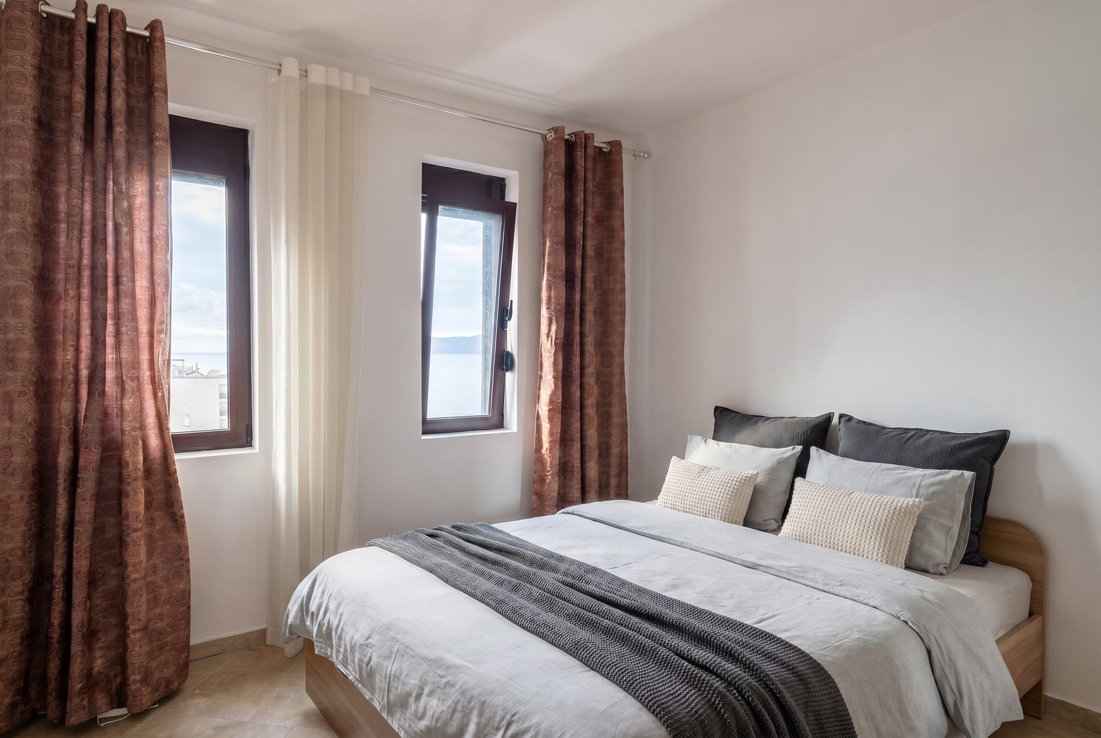 Bright bedroom with a double bed and sea view in an apartment in Rafailovici, Montenegro.
