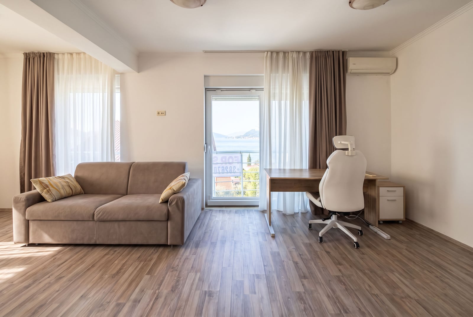 Living room with a sofa and a work area in an apartment in Tivat, Montenegro, with a sea view
