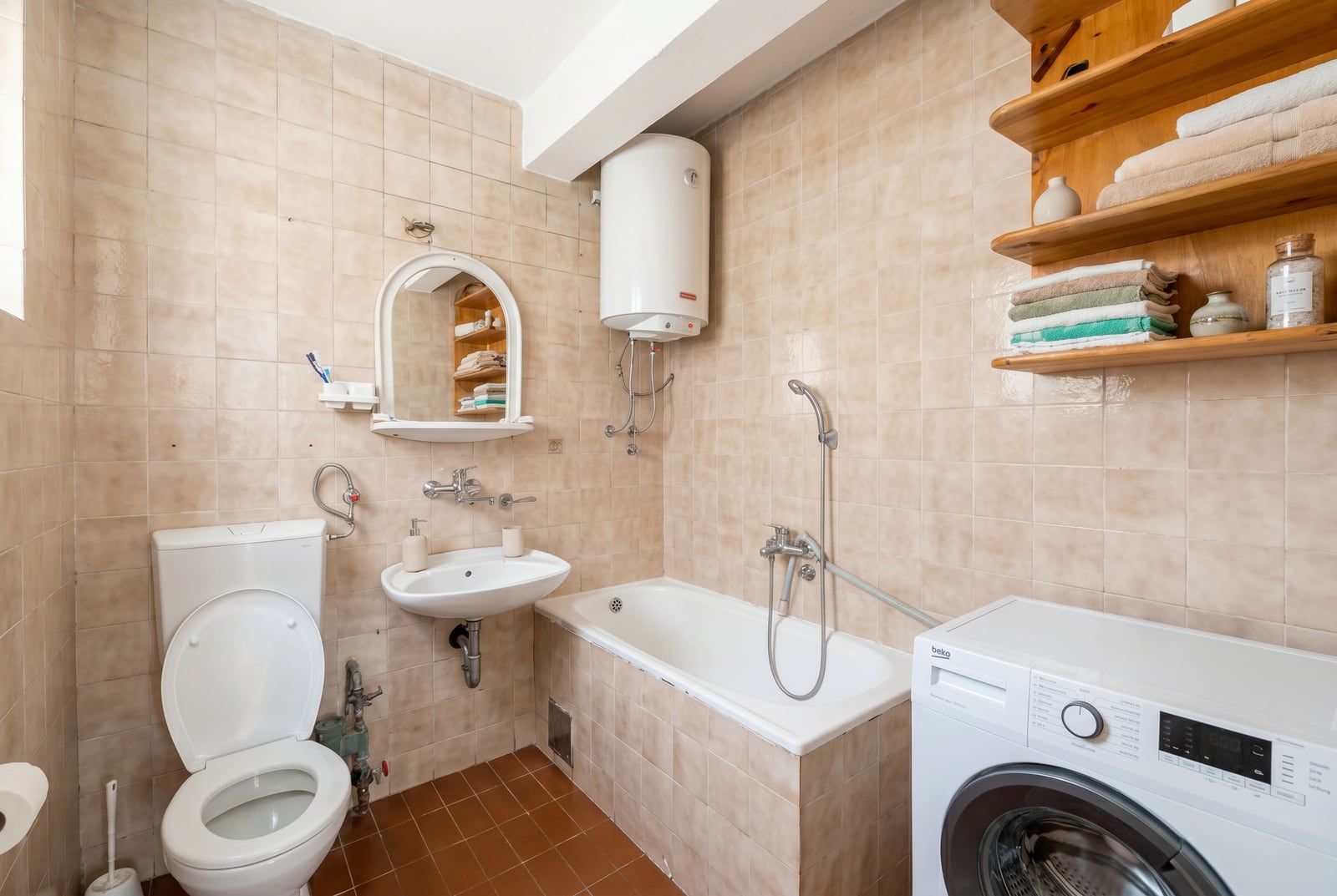 Bathroom in an apartment in Budva, Montenegro: tile, bathtub, sink, mirror, and Beko washing machine.