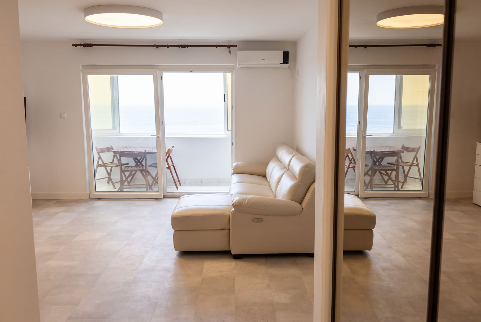 Living room with a leather sofa and access to a terrace with sea views in an apartment, Sveti Stefan, Montenegro.