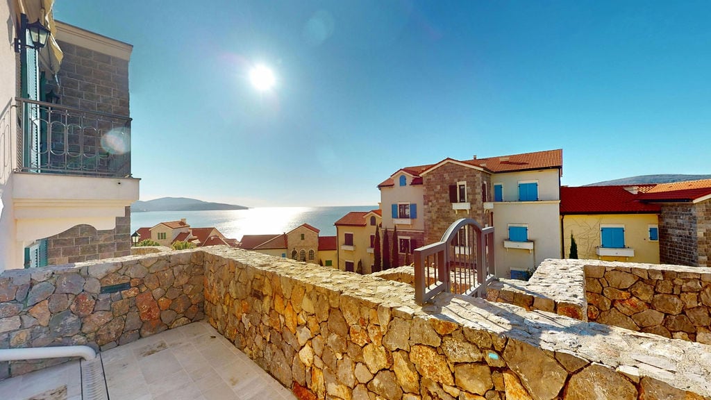Stone-finished terrace with panoramic sea views at the Luštica Bay residential complex, Montenegro.