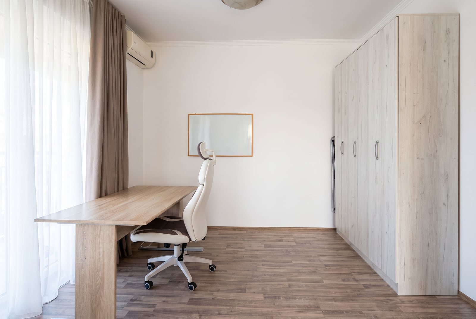 Workspace with a desk, chair, and large wardrobe in the bedroom of an apartment in Tivat, Montenegro