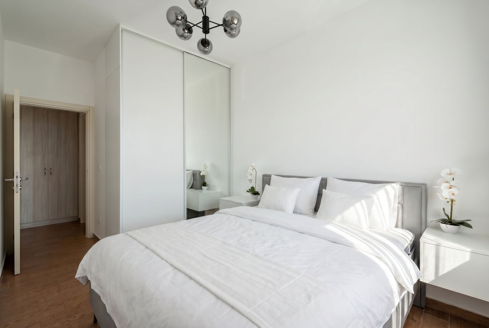 Modern bedroom with a double bed and a mirrored wardrobe in an apartment, Becici, Montenegro.