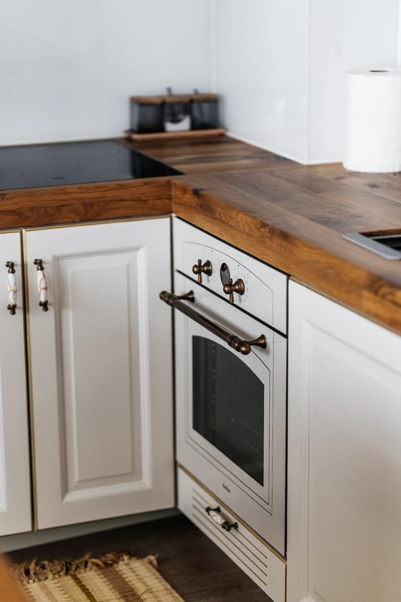 Bright classic-style kitchen with a wooden countertop in an apartment in Budva, Montenegro. Built-in oven.