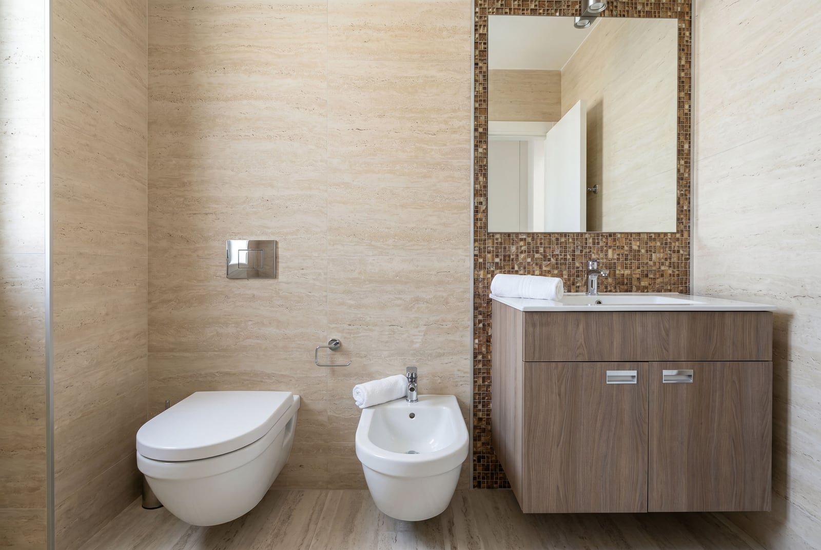 Modern bathroom with beige stone finishes in an apartment in Budva, Montenegro: sanitary ware and vanity unit
