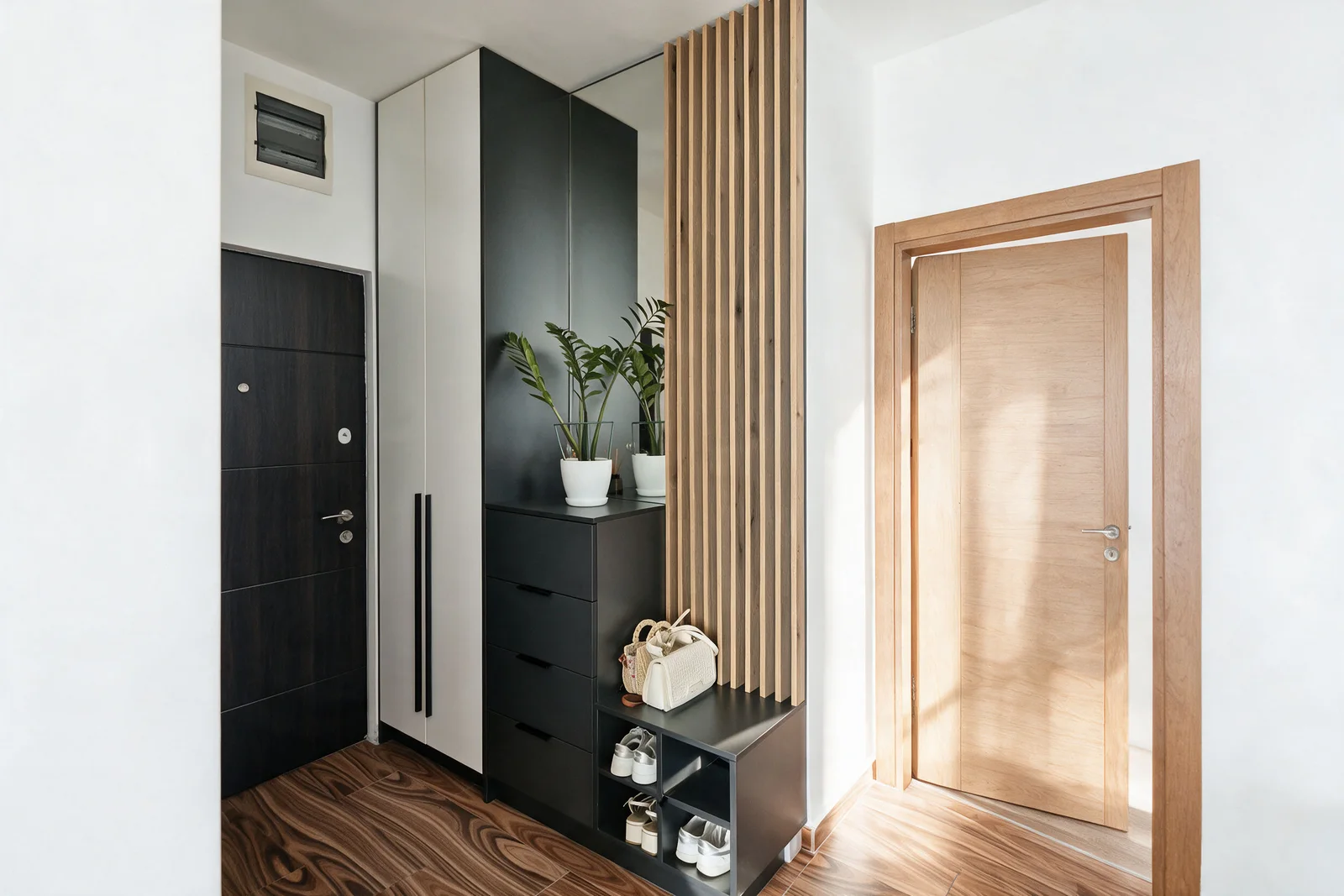 Entryway featuring a black shoe cabinet, wooden slat partition, dark entrance door, and light wood interior door.