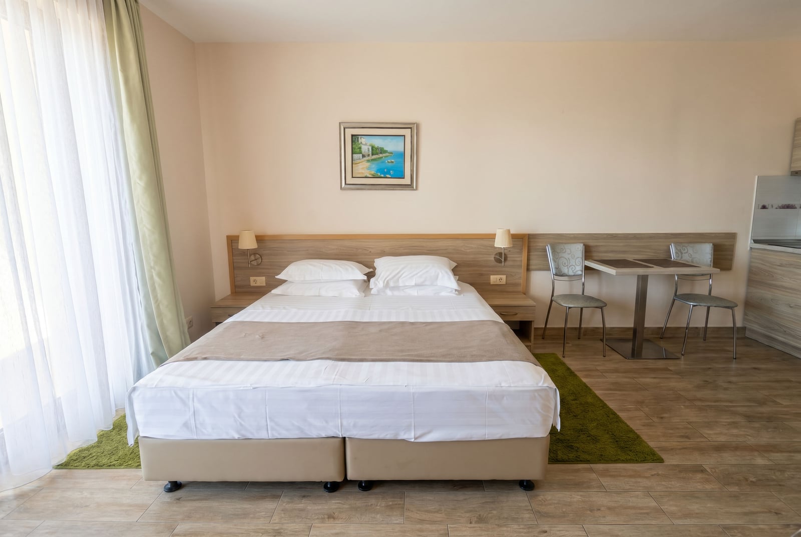 Modern bedroom in an apartment in Bečići, Montenegro: double bed, dining area, and bright interior.