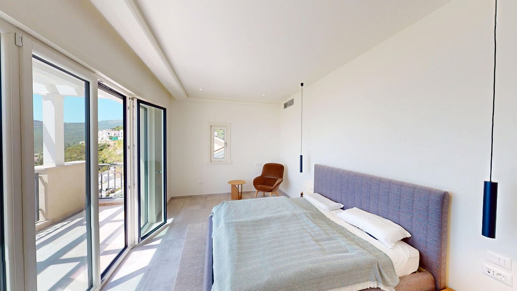 Modern bedroom with a double bed and terrace access in a residential complex, Luštica, Montenegro.