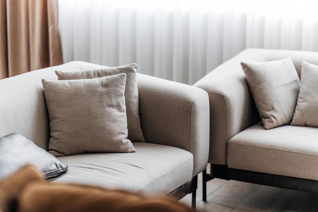 Modern living room with beige armchairs and decorative pillows in an apartment in Budva, Montenegro.