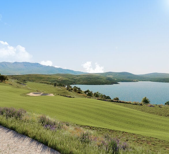Panoramic view of the golf course and sea at the Luštica Bay residential complex, Montenegro: green lawns and mountain landscape.