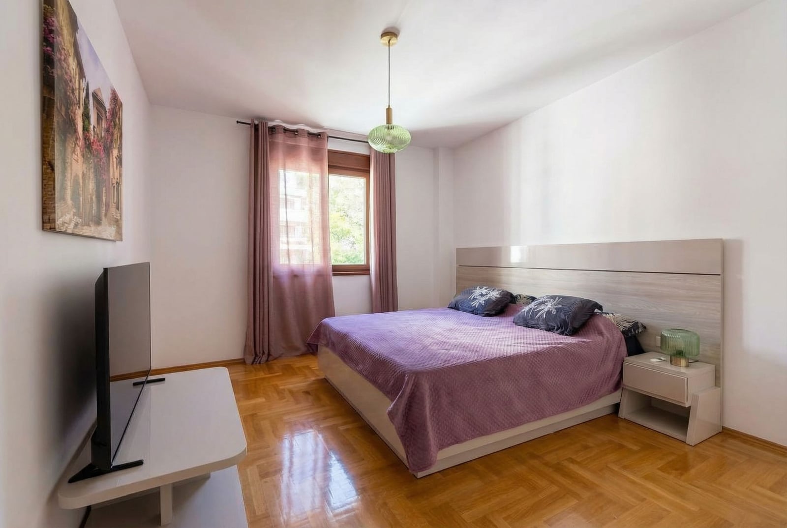Cozy bedroom with a double bed and parquet flooring in an apartment for sale, Bečići, Montenegro.