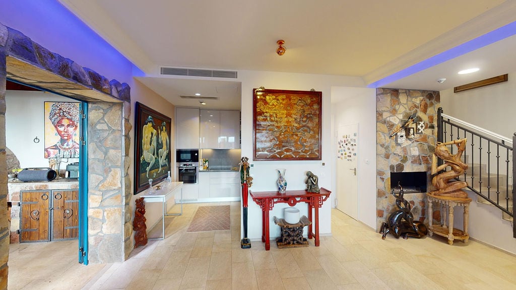 Living room with stone finishes and designer decor in a townhouse, Luštica, Montenegro: modern kitchen and staircase.