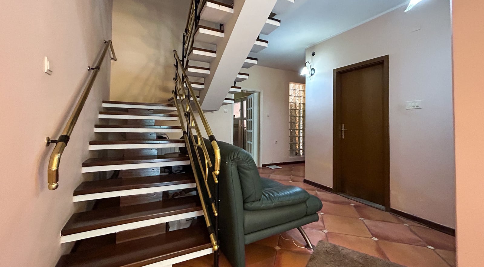 Living room interior with a wooden staircase and a leather sofa in a villa in Dobrota, Montenegro.