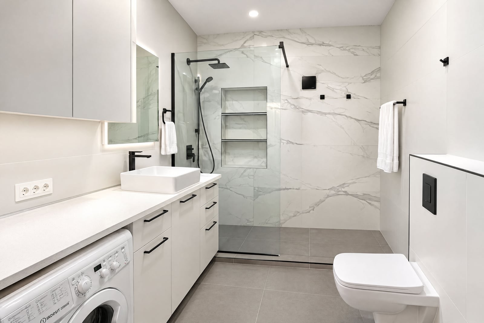 Modern bathroom featuring a glass shower, vessel sink, wall-mounted toilet, and integrated washing machine.