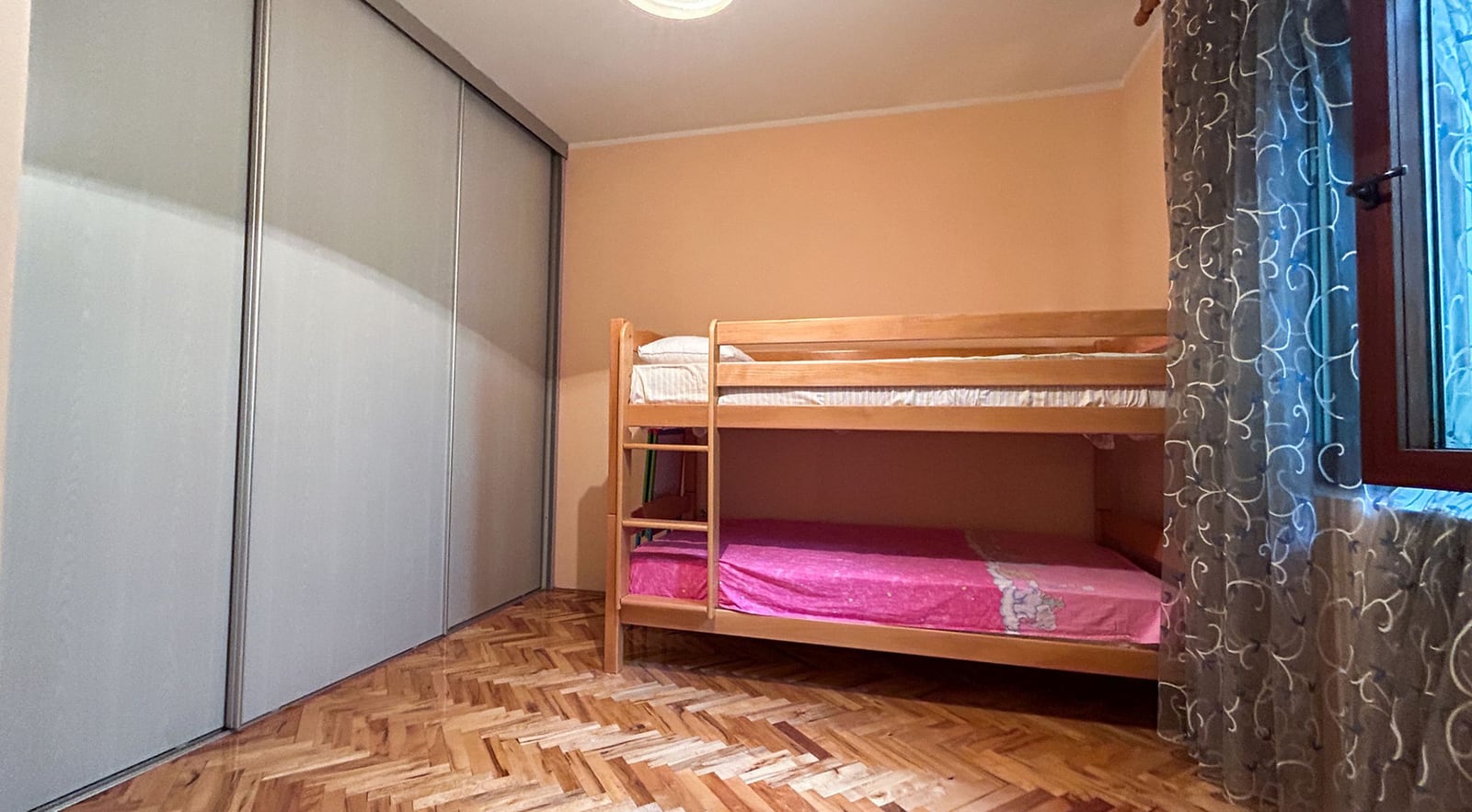Children's bedroom with a bunk bed and built-in sliding wardrobe in a villa in Dobrota, Montenegro.