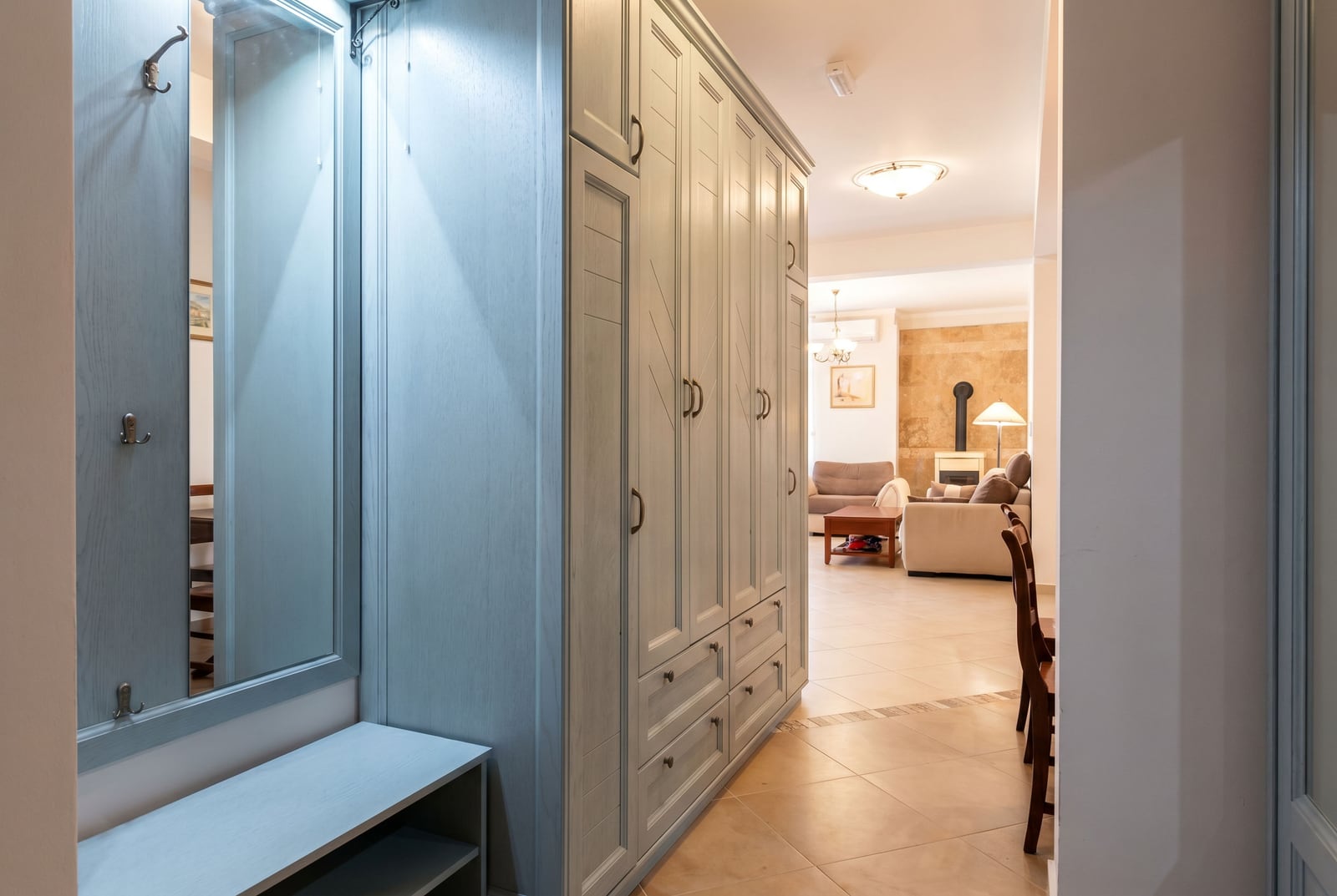 Entrance hall with a large built-in wardrobe and a mirror in an apartment in Bar, Montenegro, overlooking a cozy living room.