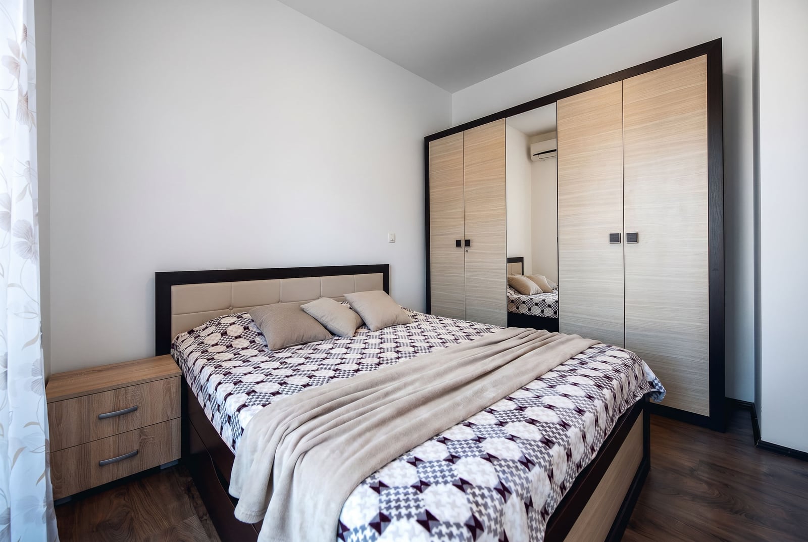 Bedroom in an apartment in Budva, Montenegro: double bed, built-in wardrobe with mirror, and light interior finishes.