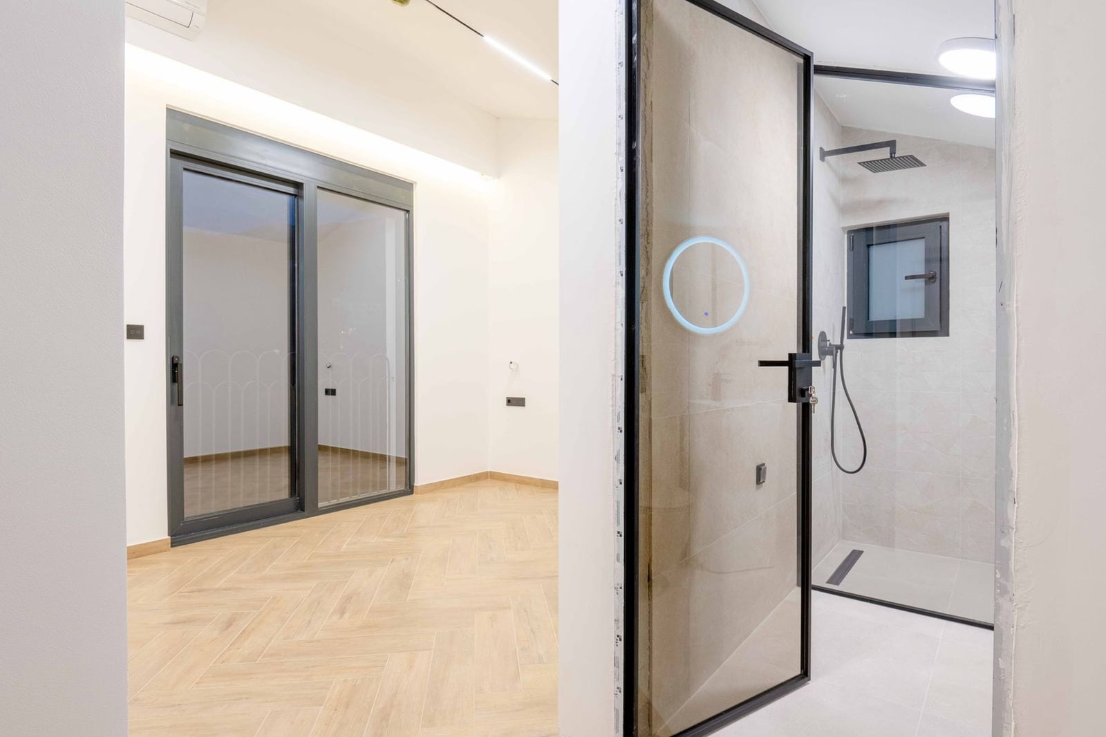 Modern bedroom with panoramic window and bathroom in a new villa, Kamenovo, Montenegro. Bright interior.
