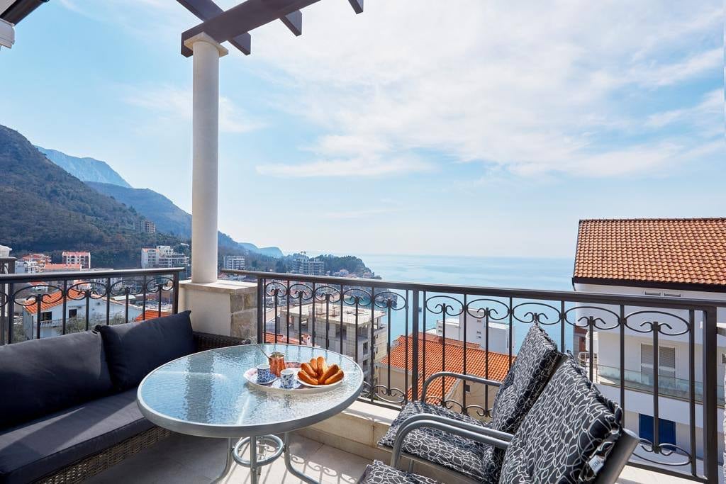 Terrace with furniture and panoramic sea and mountain views in an apartment, Pržno, Montenegro.