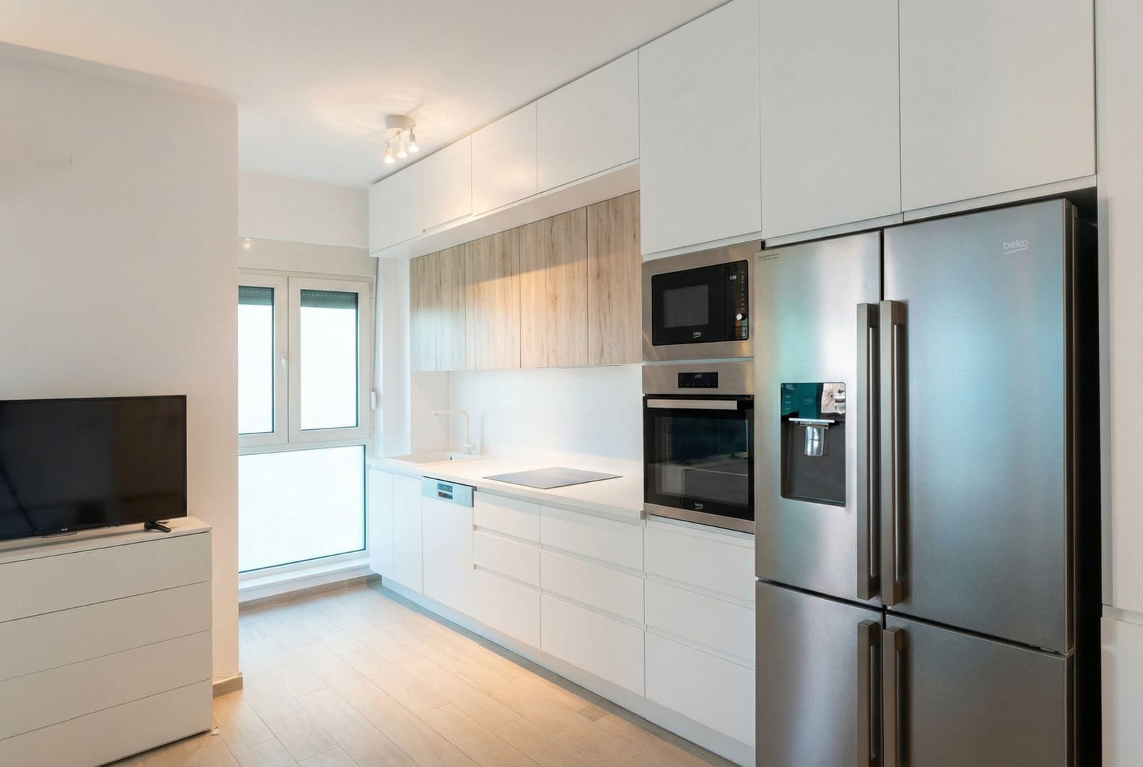 Modern kitchen in an apartment in Bečići, Montenegro: white cabinets, built-in Beko appliances, and a bright interior.