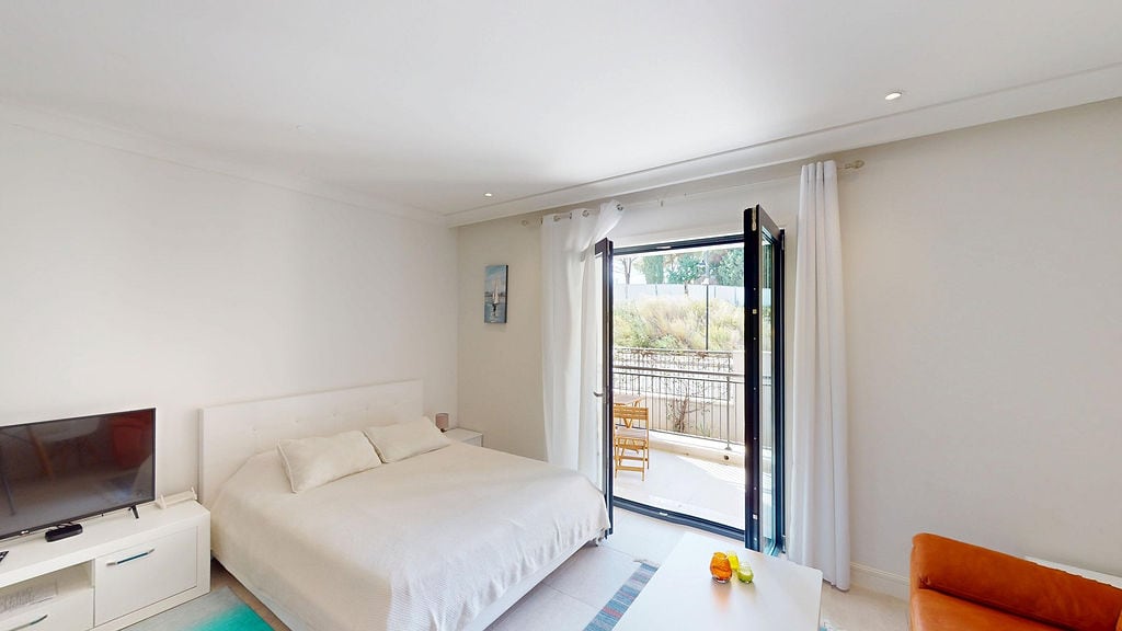 Bright bedroom with a double bed and balcony access in a residential complex, Luštica, Montenegro.