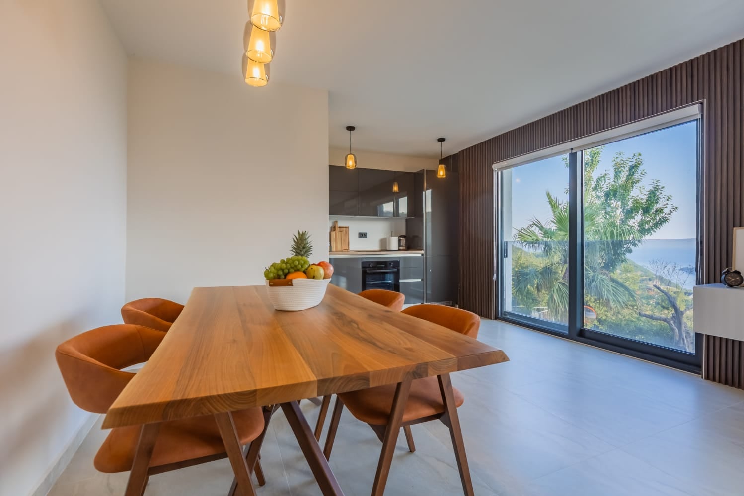 Modern living room with dining area in a villa in Budva, Montenegro: panoramic windows with sea and garden views.