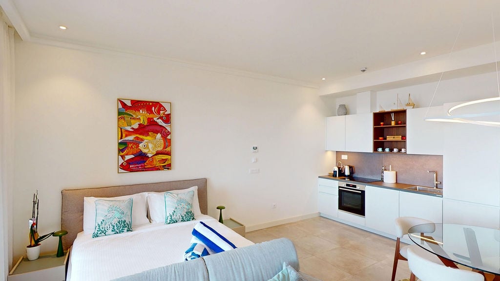 Modern studio with kitchen and bed in the Luštica residential complex, Montenegro: bright interior, built-in appliances, decor.