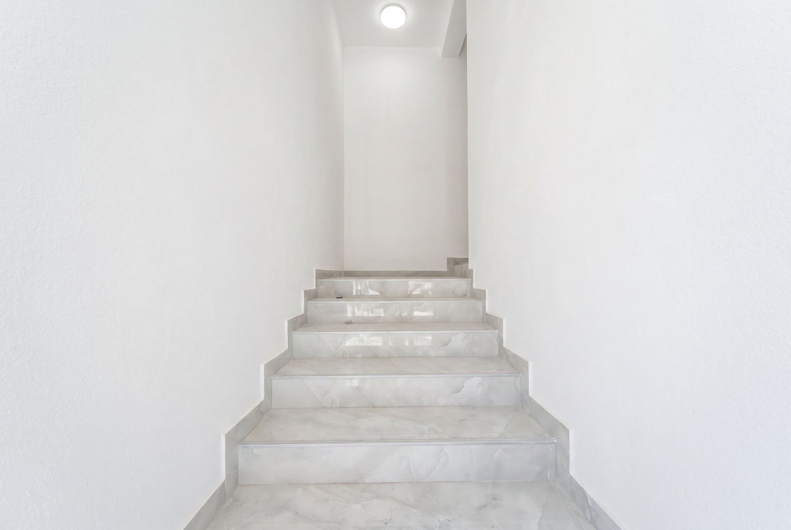 White staircase with marble finishing in a modern apartment in the city of Bar, Montenegro