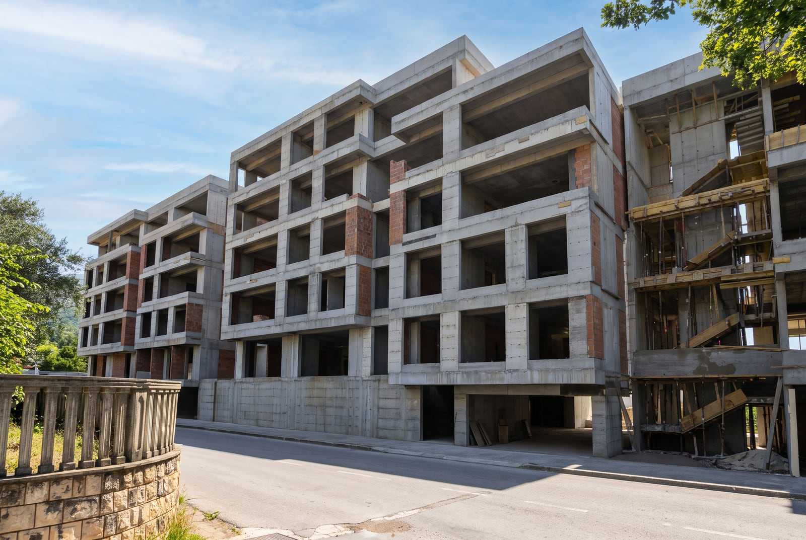 Exterior view of a multi-story residential building under construction, showing unfinished concrete structure and brickwork.