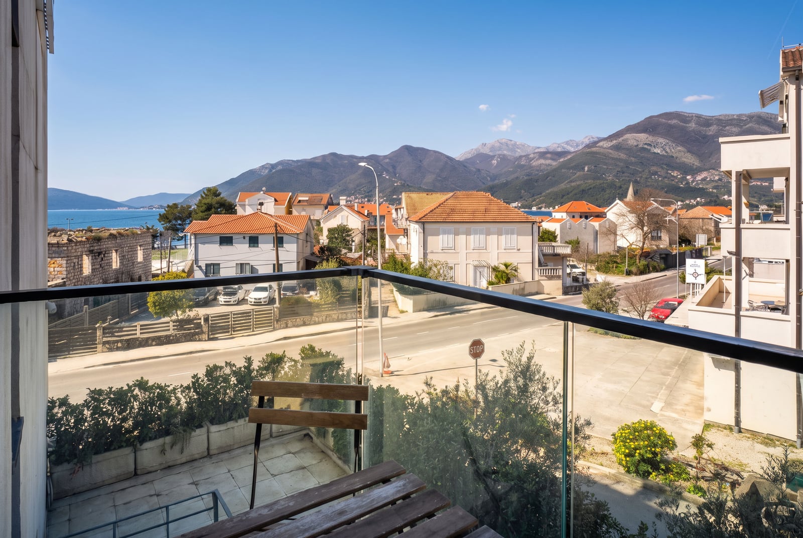 View from the balcony of an apartment in Tivat, Montenegro: panorama of mountains, sea, and urban development.