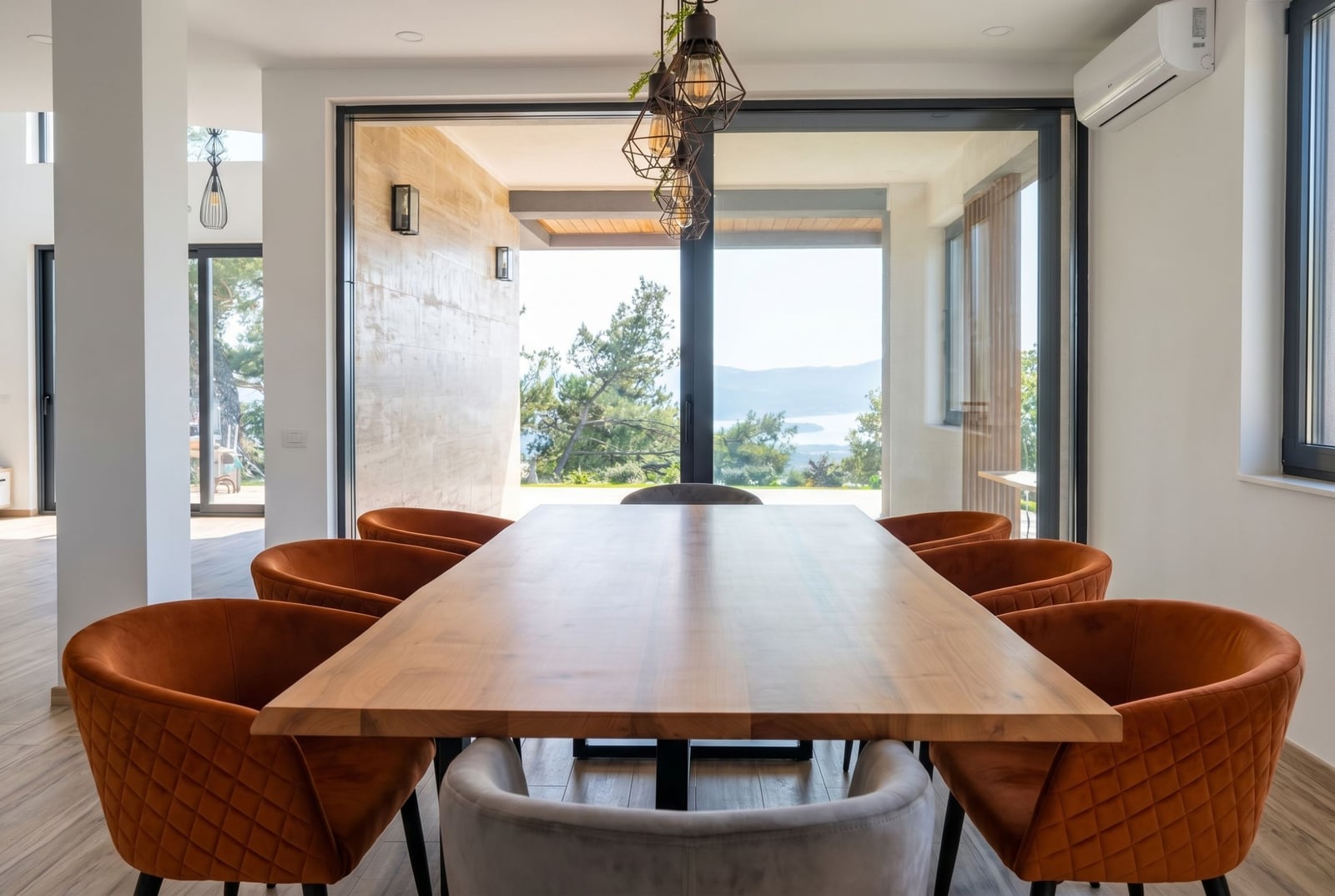 Modern living room with a wooden table and a terrace overlooking the sea in a villa, Kavac, Montenegro.