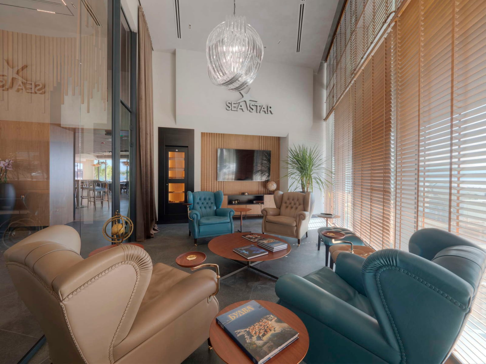 Modern lounge area with leather armchairs, TV, and Sea Star logo on the wall.