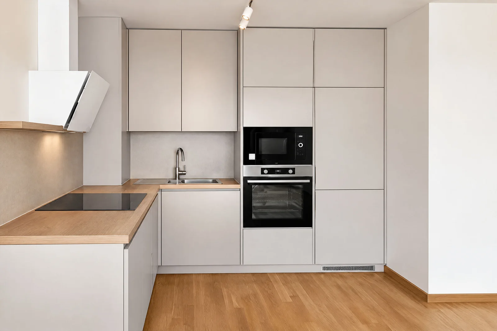 Modern kitchen featuring beige cabinets, wooden countertops, built-in oven, microwave, induction cooktop, and sink.