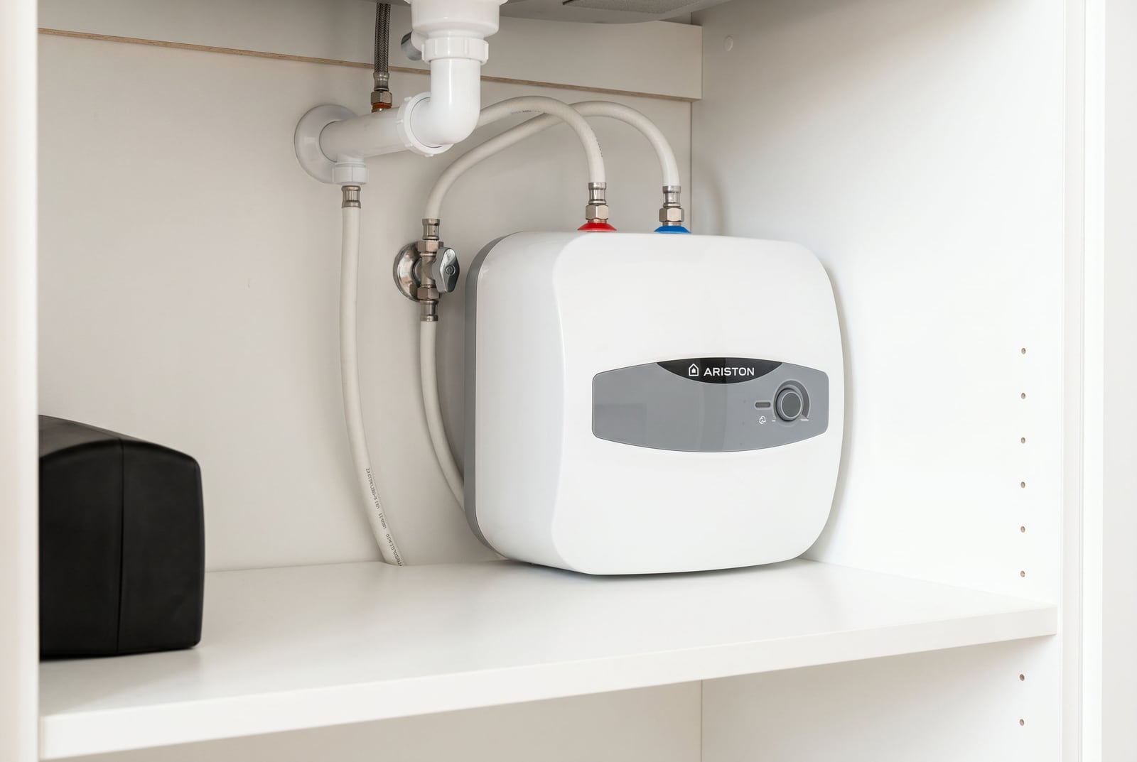 Compact water heater under the sink in the bathroom of an apartment in Budva, Montenegro