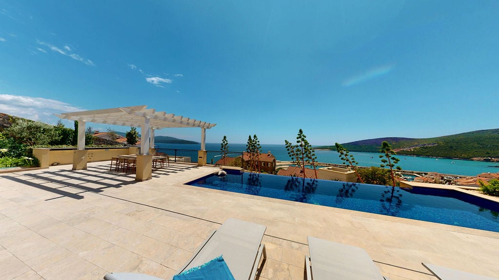 Infinity pool with sea view and terrace with pergola at a villa in Luštica, Montenegro.