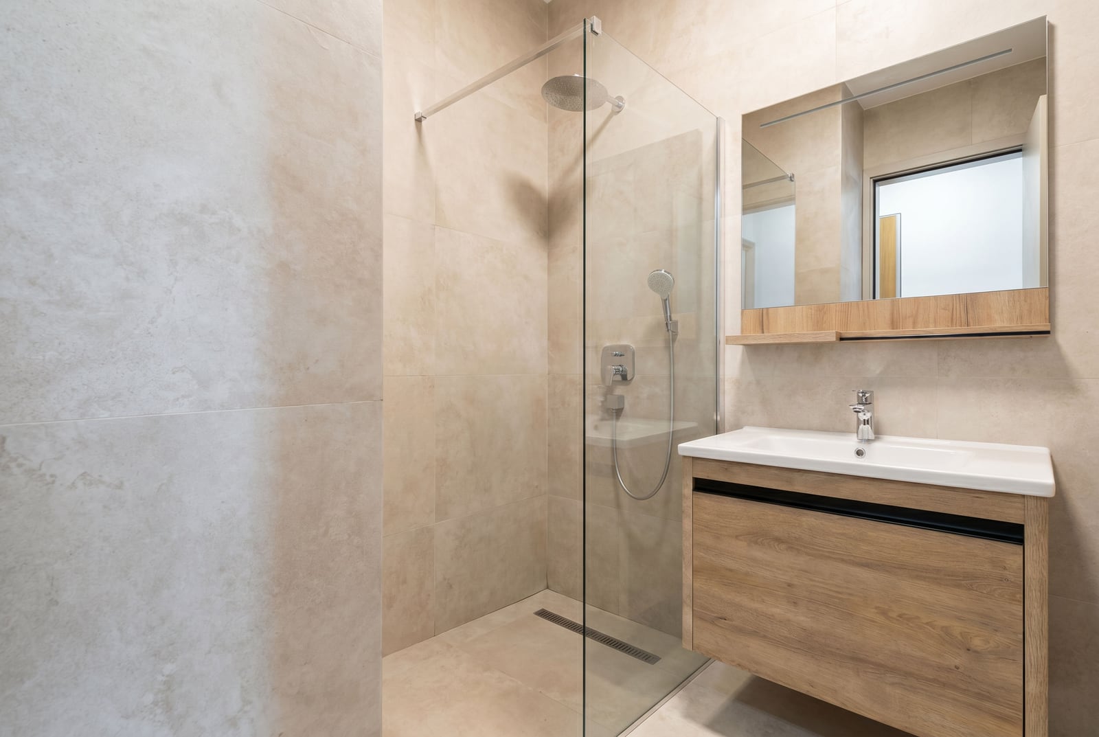Modern bathroom in an apartment in Bečići, Montenegro: walk-in shower, vanity unit, and mirror.