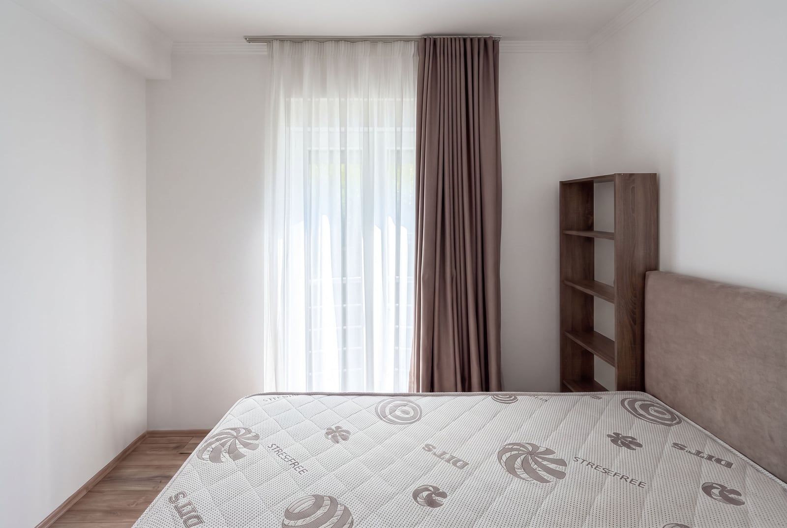 Bright bedroom with a bed, wardrobe, and a window with blackout curtains in an apartment in Tivat, Montenegro