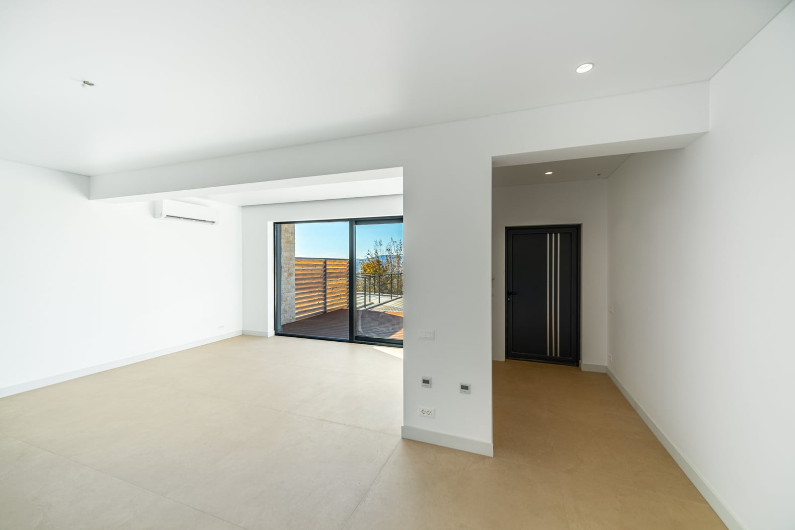 Bright living room in a townhouse, Kavač, Montenegro: panoramic windows, access to the terrace, modern finishes, and air conditioning.