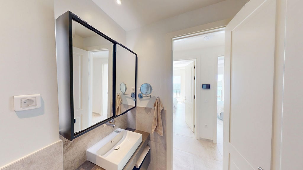 Modern bathroom with a mirror and sink in a residential complex on the Luštica Peninsula, Montenegro.